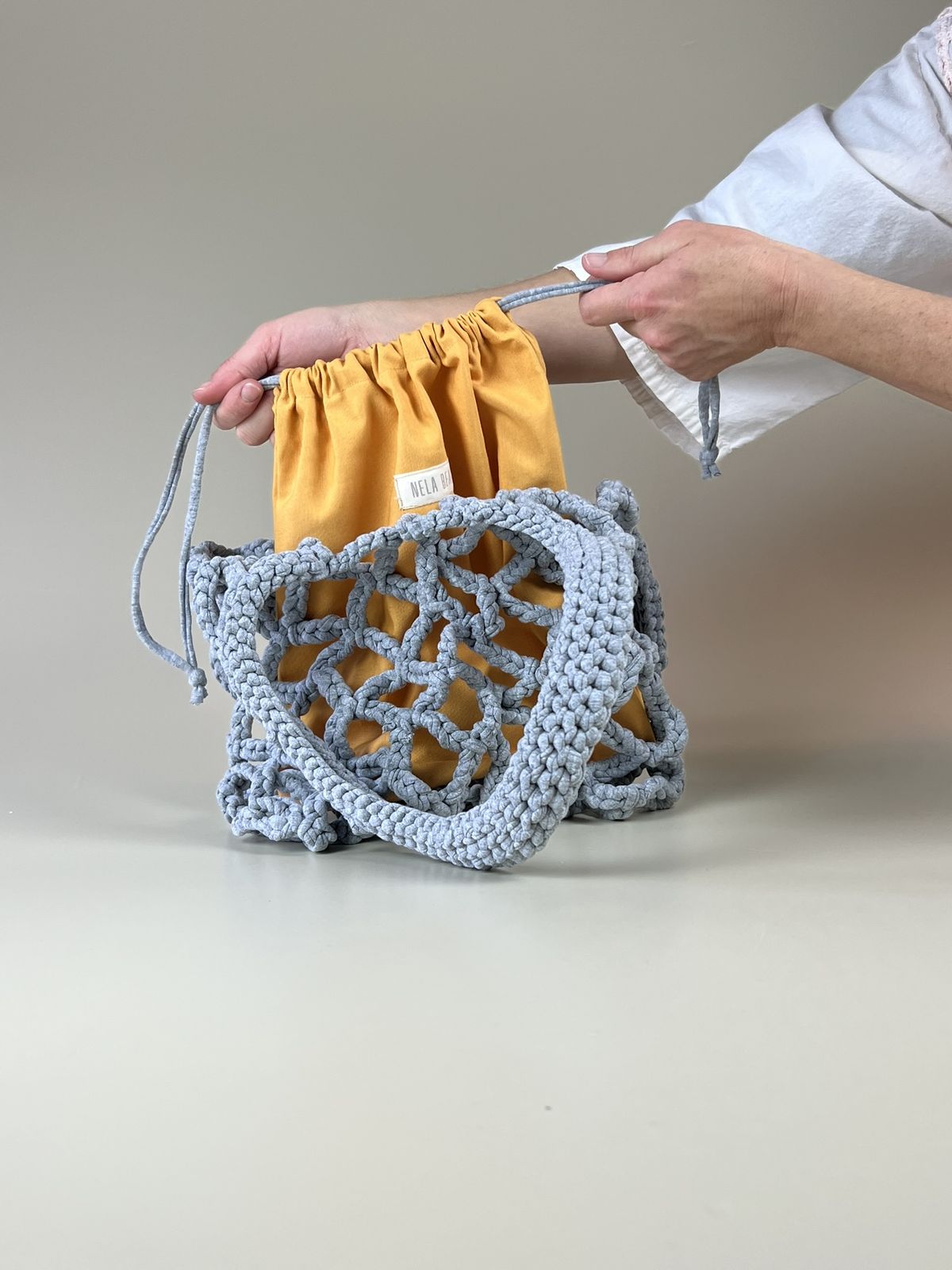 Detalle del tejido en punto grande del bolso Roudera, hecho a mano con materiales sostenibles y diseño transpirable."