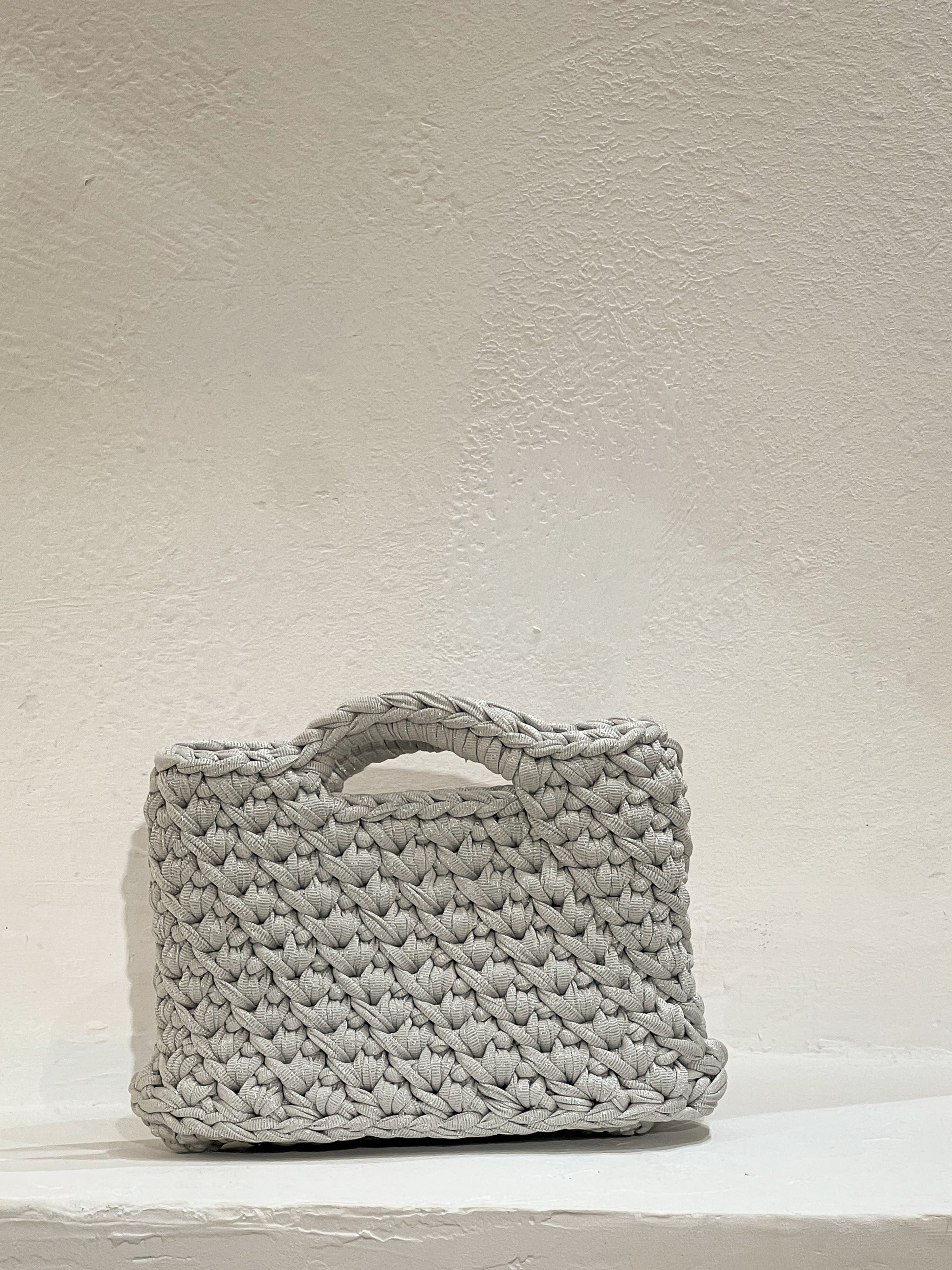 Bolso a crochet modelo Nela plata, tejido a mano con hilos reciclados y sostenibles por Nela Beach en Mallorca.